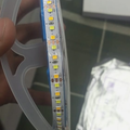 5V LED Strip Light 10 Meter Roll - Yellow & White - a close-up of the flexible strip coiled on a plastic spool with visible +5V labels.