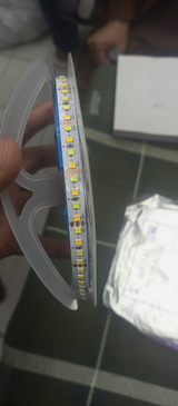 5V LED Strip Light 10 Meter Roll - Yellow & White - a close-up of the flexible strip coiled on a plastic spool with visible +5V labels.