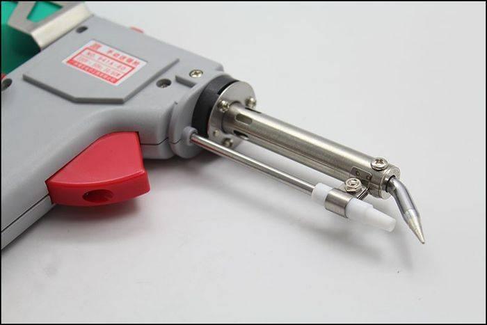 60W Manual Automatic Tin Welding Gun 941-60 Soldering Gun - a close-up view of the grey plastic soldering gun featuring a red trigger and a metal heating element tip.