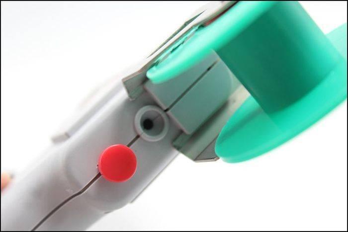 60W Manual Automatic Tin Welding Gun 941-60 Soldering Gun - close-up view showing the grey handle, a red button, a small circular port, and a teal spool holder.