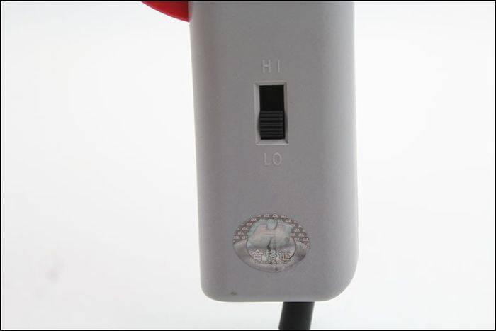60W Manual Automatic Tin Welding Gun 941-60 Soldering Gun - a close-up of the grey handle featuring a HI/LO toggle switch and a circular holographic quality sticker.