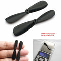 614 Motor Small Nylon Propeller Blade Shaft 0.8mm 46mm Cw+ccw Blades - shown as a set of two black propellers, one held in a hand, and one on a scale.