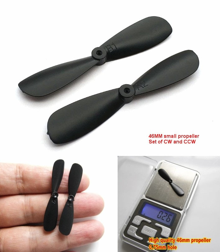 614 Motor Small Nylon Propeller Blade Shaft 0.8mm 46mm Cw+ccw Blades - shown as a set of two black propellers, one held in a hand, and one on a scale.