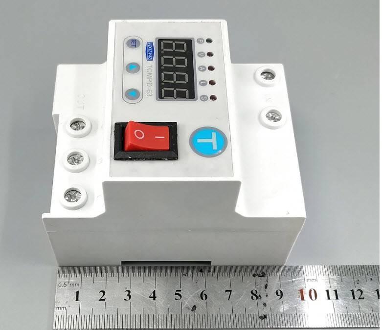 63A Automatic Re connection Circuit Breaker Over and Under Voltage Leakage Protection Current to Protect Relay - TOMZN TOMPD-63 circuit breaker, a white DIN-rail device with a digital display, buttons, a red power switch, and a metal ruler showing its dimensions.