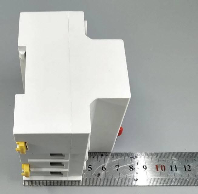 63A Automatic Re connection Circuit Breaker Over and Under Voltage Leakage Protection Current to Protect Relay - shown from the side, featuring yellow terminals and a metal ruler indicating its dimensions in millimeters.