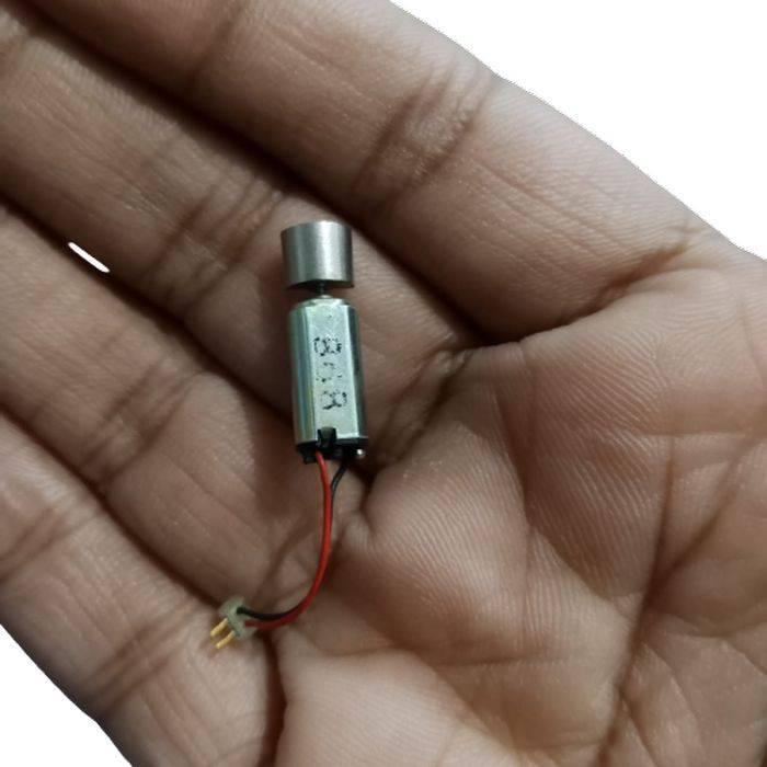 6mm x 12mm Mini Coreless Vibration Motor - shown held in a palm, featuring a silver cylindrical body with a small connector and two wires.