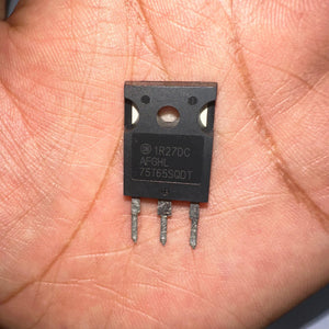75A 650V On Semiconductor 75T65SQDT IGBT With Soft Fast Recovery Diode-digilog.pk - close-up view of a black, three-pin semiconductor component held in a palm, showing the text 1R27DC, AFGHL, and 75T65SQDT printed on it.