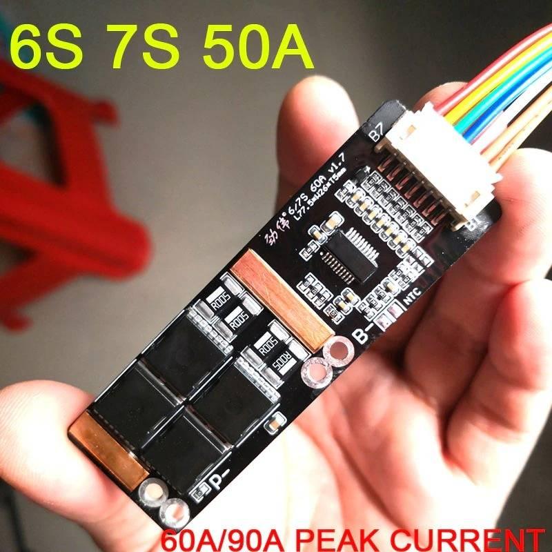 7s 50A BMS - a black rectangular circuit board held in a hand, featuring a white multi-pin connector, several MOSFETs, and labeled B- and P- terminals.