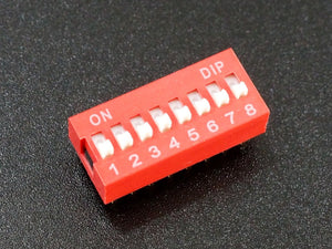 8-position DIP Switch – Slide Type, PCB Mount, 8-bit Manual Address Switch - a red rectangular electronic component with eight white manual slide switches labeled 1 through 8 on a black background.
