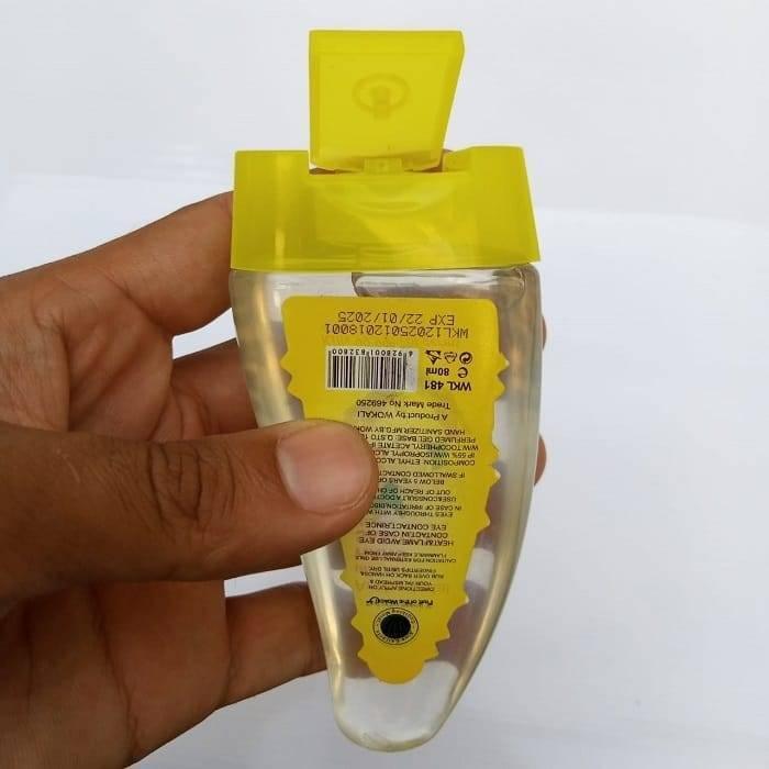 80ML Instant Liquid Soap Hand Sanitizer - clear plastic bottle with a yellow flip-top cap, held in a hand showing the product label details.