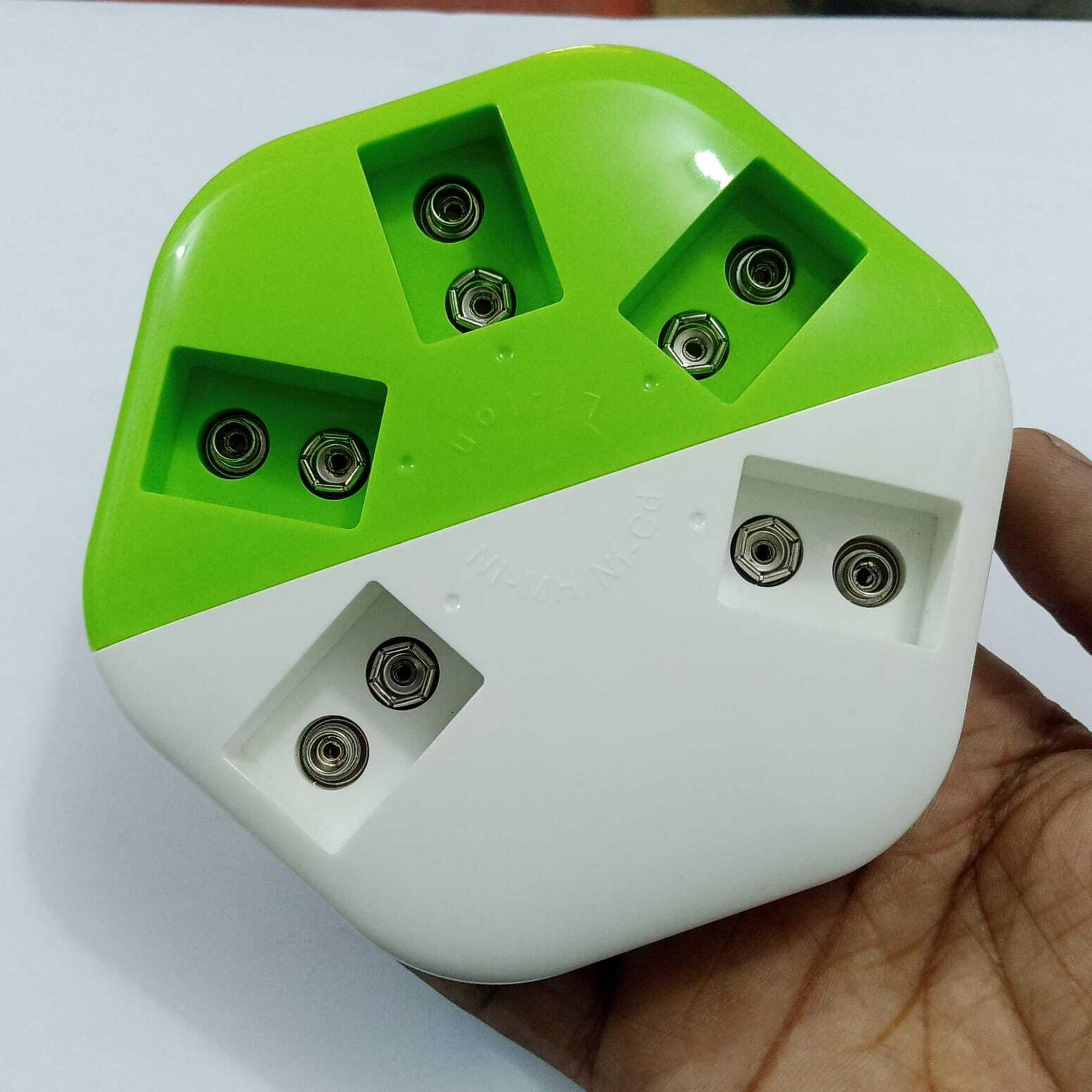 9V Universal Battery Charger - a white and green plastic device with five pairs of metal contact points for charging 9V batteries.