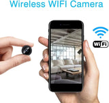 A9 Mini Wi-Fi Camera 1080P Full HD Wireless Ip Camera - a small black circular lens held by fingers next to a smartphone displaying a live view of a living room interior.