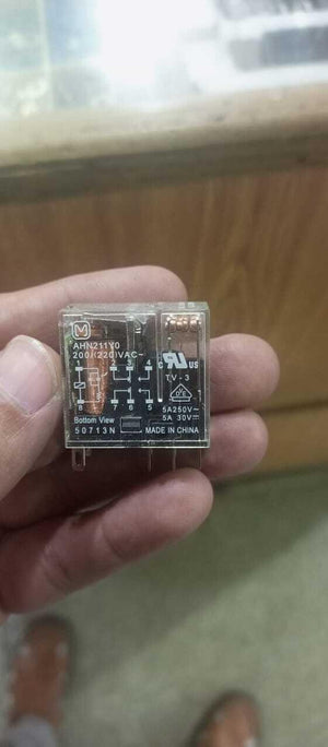 AC Relay Coil AC220V AHN211YO - held in a hand, showing the clear plastic casing, terminal pins, and technical specifications printed on the face.