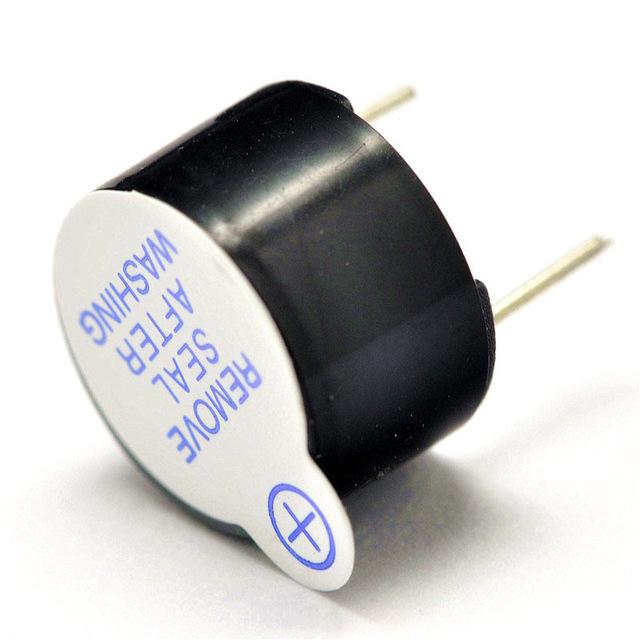 Active Piezo Buzzer 3V To 12V Active Buzzer for Arduino - a black cylindrical electronic component with two metal pins and a white label reading REMOVE SEAL AFTER WASHING.