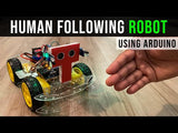 Arduino Human Following Robot (Unassembled Only Parts) - four-wheeled robotic chassis with a red T-shaped sensor mount and yellow wheels on a wooden surface.