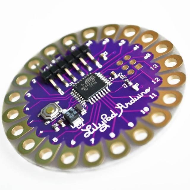 Arduino Lilypad Arduino 328 Main Board ATMEGA328P ATMEGA328 16M - a circular purple microcontroller board featuring a central ATMEGA328P chip, a reset button, and pin holes.
