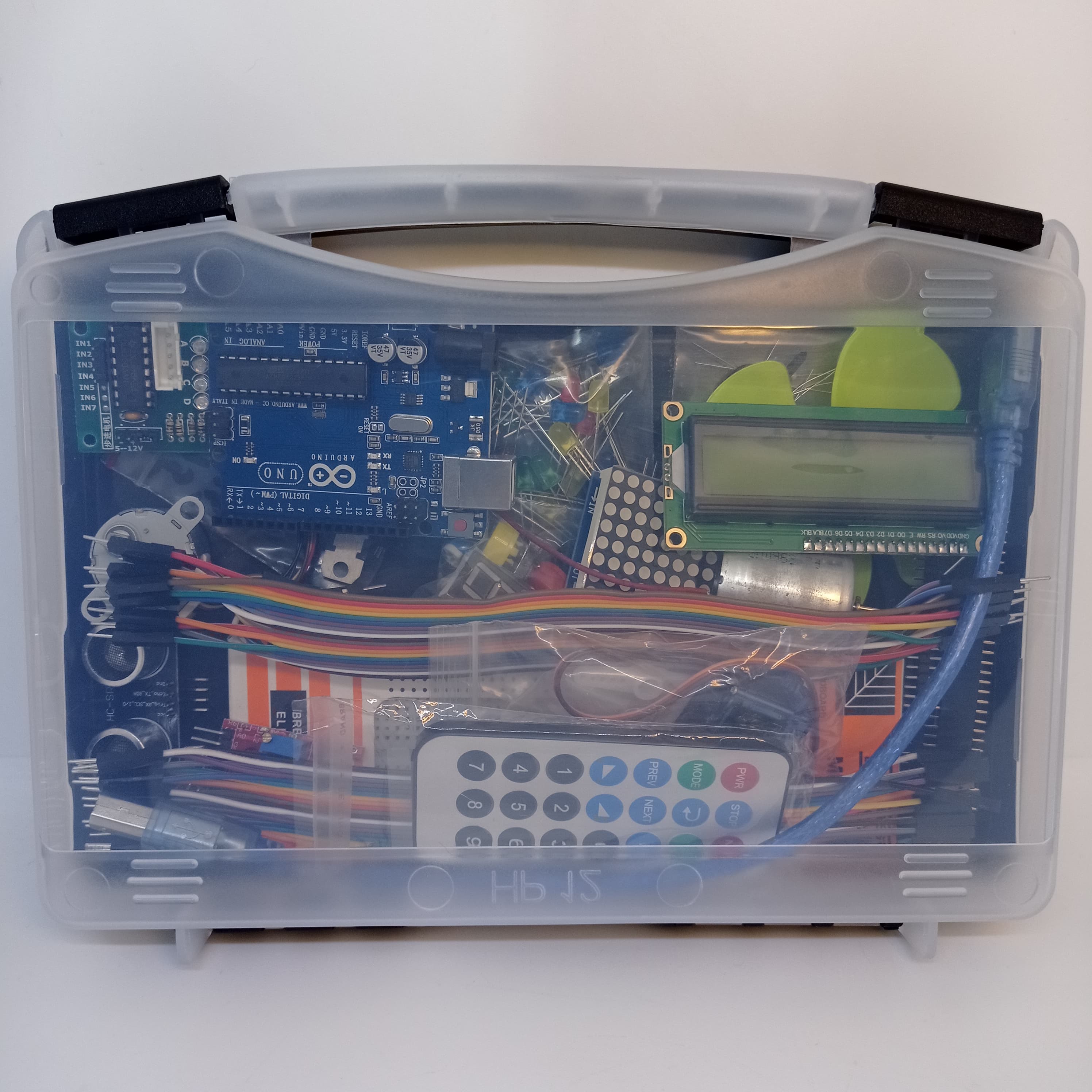 Arduino Starter Kit - clear plastic carrying case containing an Arduino Uno board, an LCD screen, a remote control, jumper wires, and components.