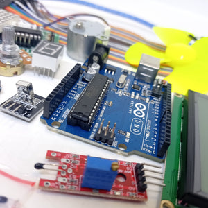 Arduino Starter Kit - a blue Arduino Uno board surrounded by a motor, fan, potentiometer, seven-segment display, sensor module, and LCD screen.