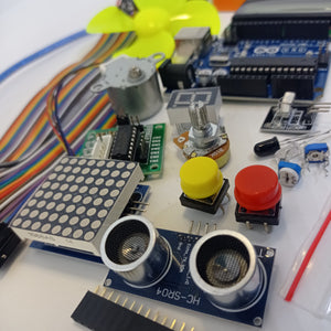 Arduino Starter Kit - an assortment of electronics including an Arduino board, ultrasonic sensor, LED matrix, motor, buttons, and jumper wires.