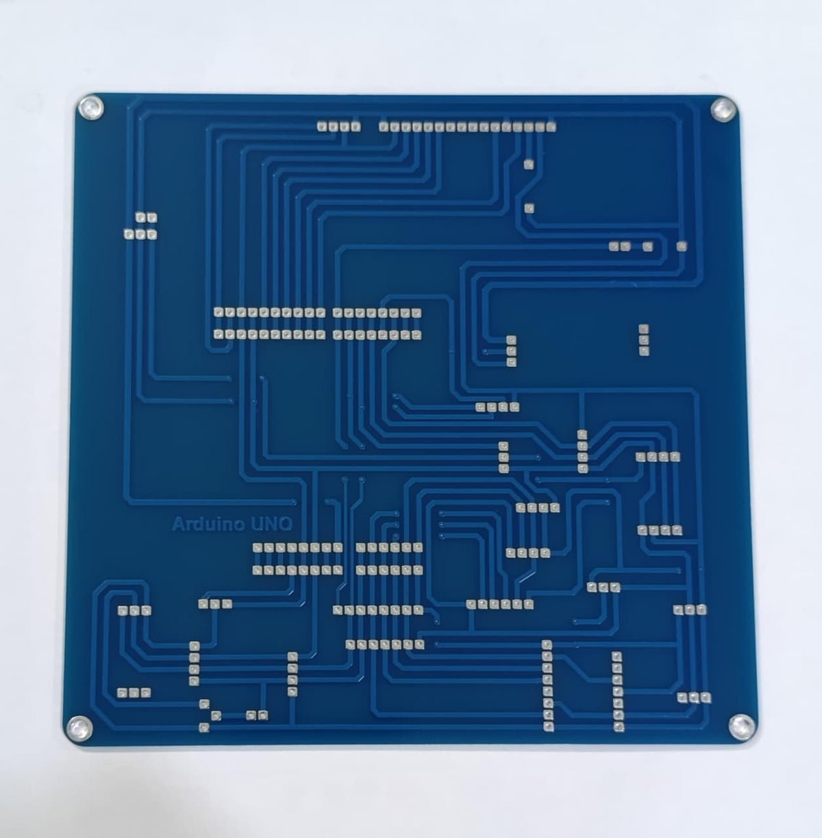 Arduino Uno R3 Training Development Board – Ultimate Sensor Learning Kit - a blue printed circuit board with metallic pads and "Arduino UNO" text visible on the surface.
