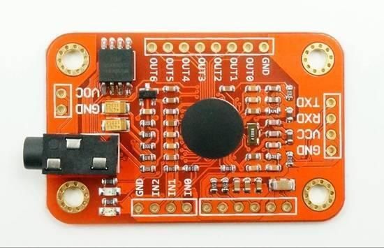Arduino Voice Recognition Module V3 - an orange rectangular circuit board featuring a black audio jack, a central circular sensor, and various pin headers.
