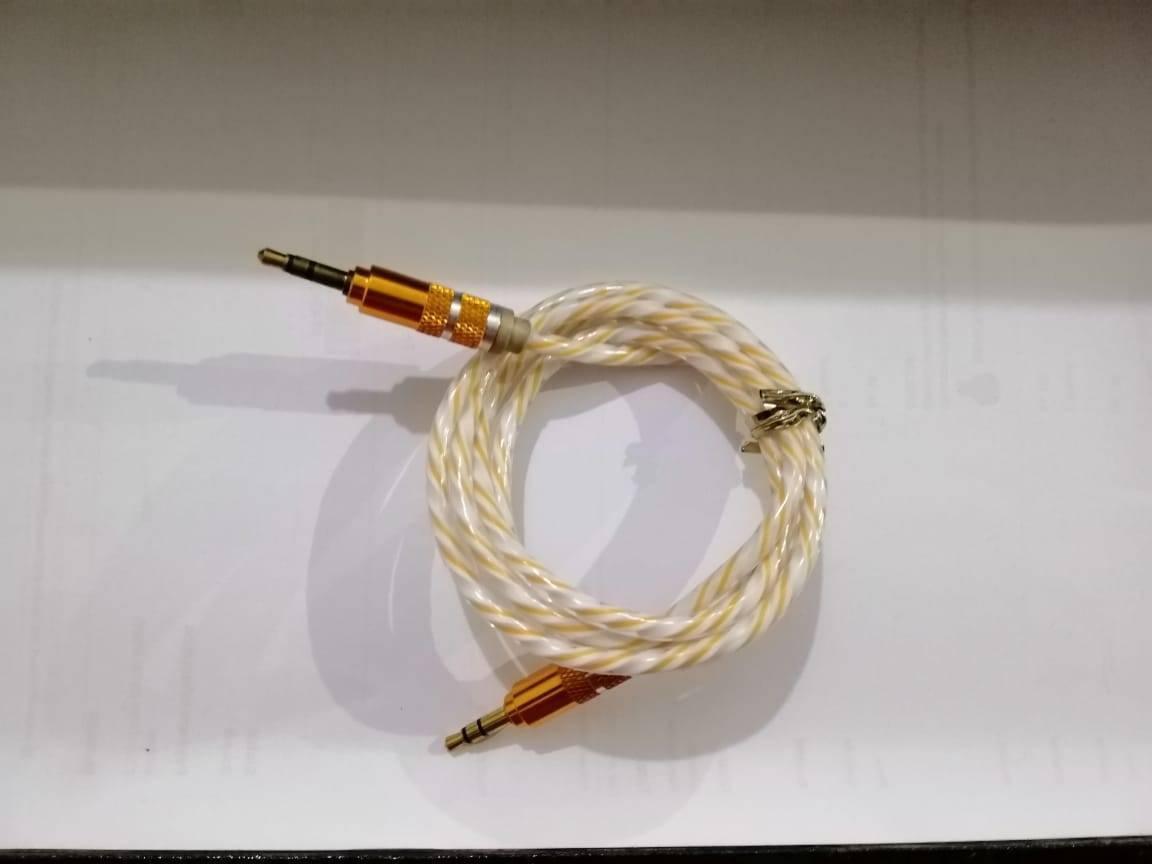 Aux Cable - a coiled white and yellow braided wire with gold-coloured 3.5mm connectors at both ends.