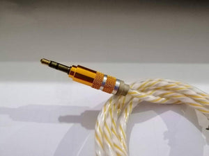 Aux Cable - a close-up of a 3.5mm gold-plated connector with a textured metallic body attached to a braided white and yellow cable.