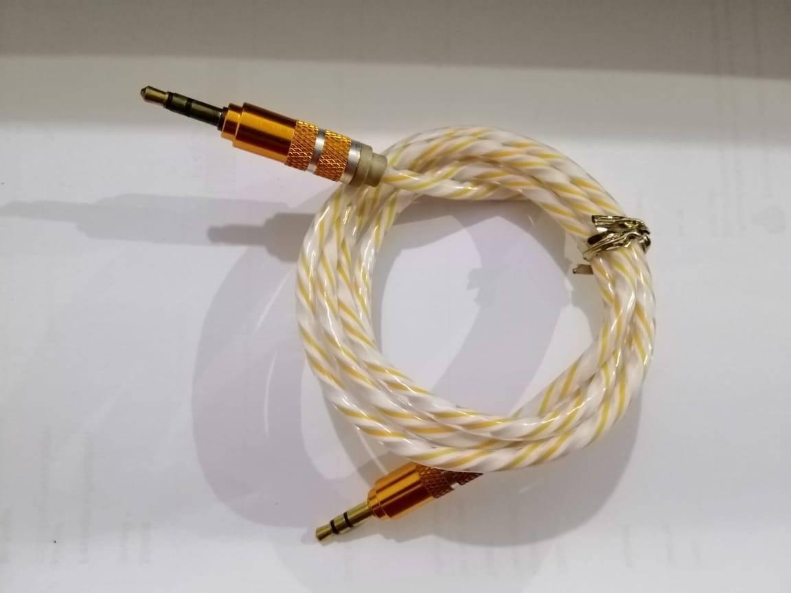 Aux Cable - a coiled, white and yellow twisted wire with gold-coloured 3.5mm jack connectors on both ends.