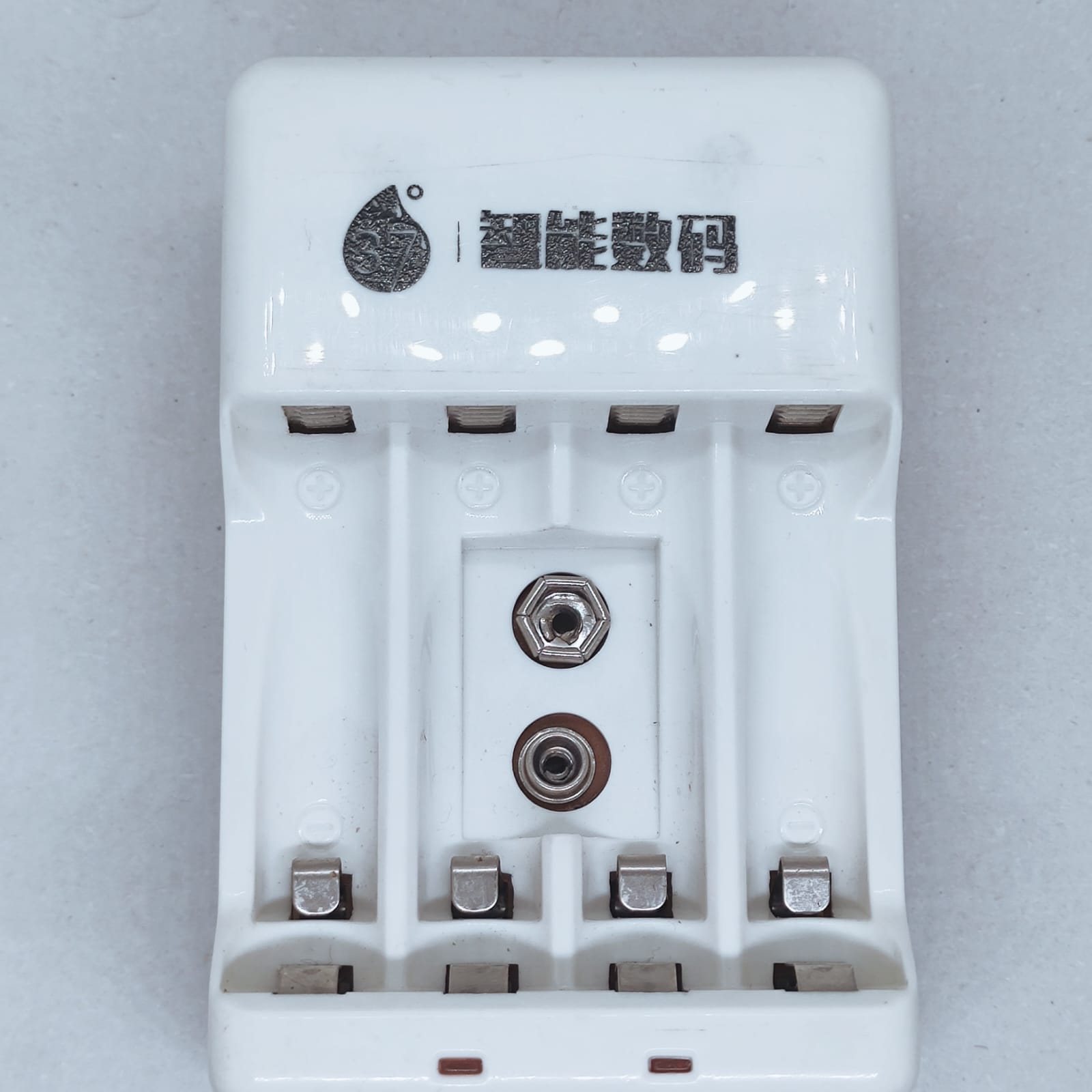 Battery Charger With Discharge Function For AA, AAA, 9V DC 20mA Rechargeable Batteries - white four-slot charger with two circular metal contacts.