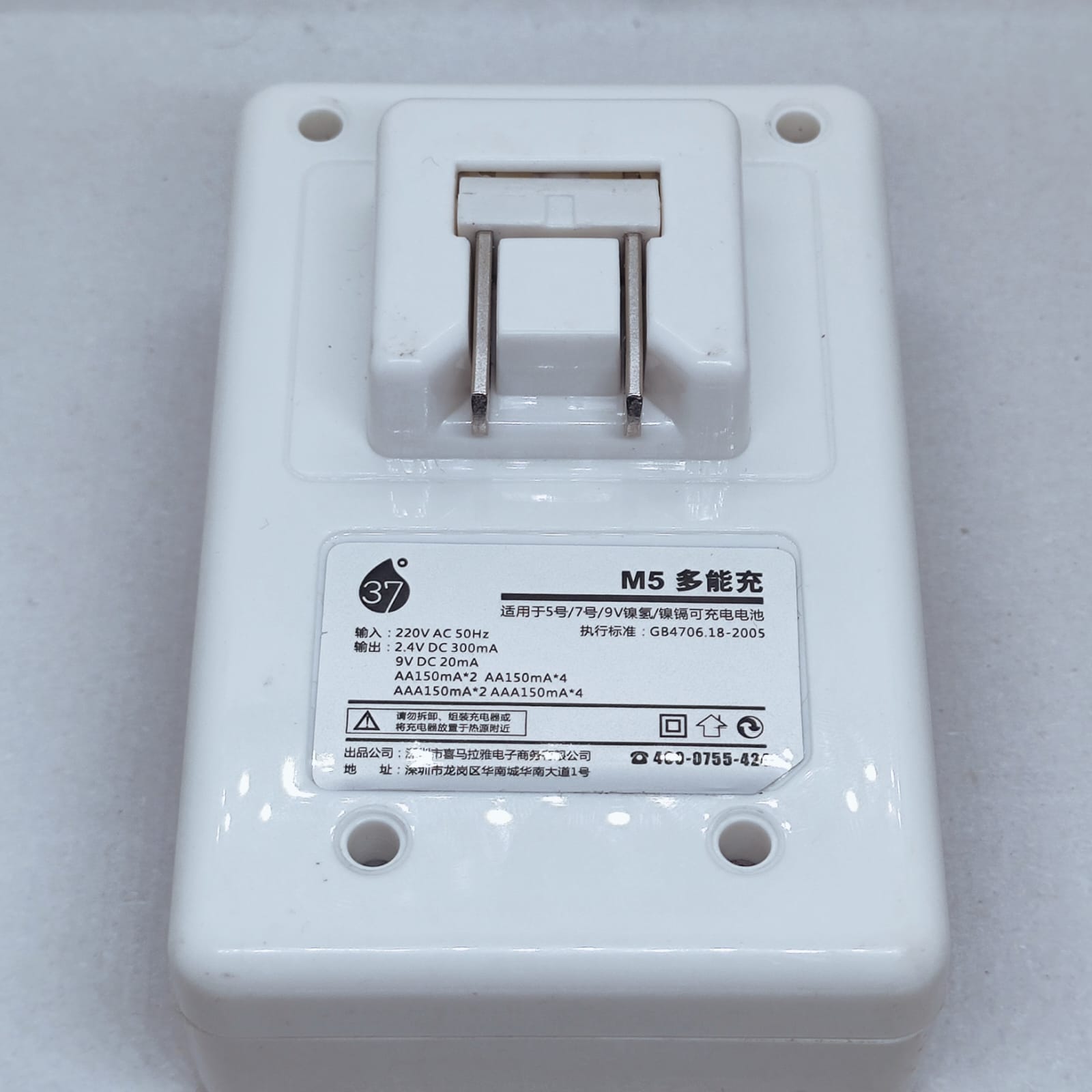 Battery Charger With Discharge Function For AA, AAA, 9V DC 20mA Rechargeable Batteries - the white plastic rear housing with a foldable AC plug and a label containing technical specifications.