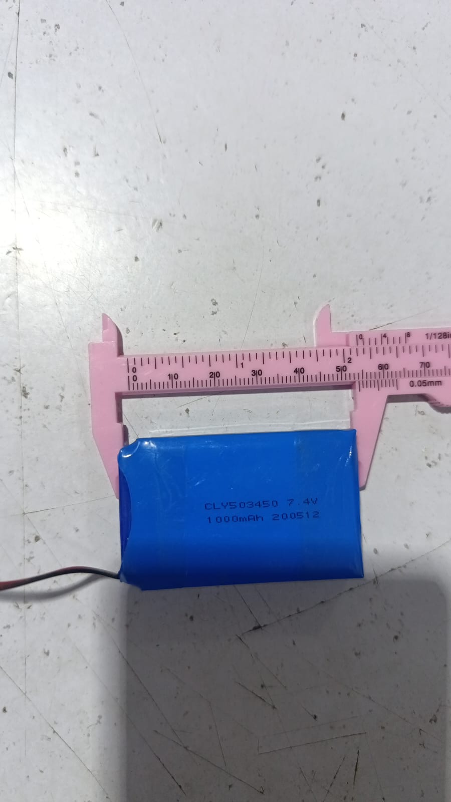 Battery Wholesale 2s 7.4V 1000mAh Rechargeable LiPo Lithium Battery Pack With JST 2.54mm Connector - shown being measured with pink calipers, displaying the model number CLY503450 and a wire connector.