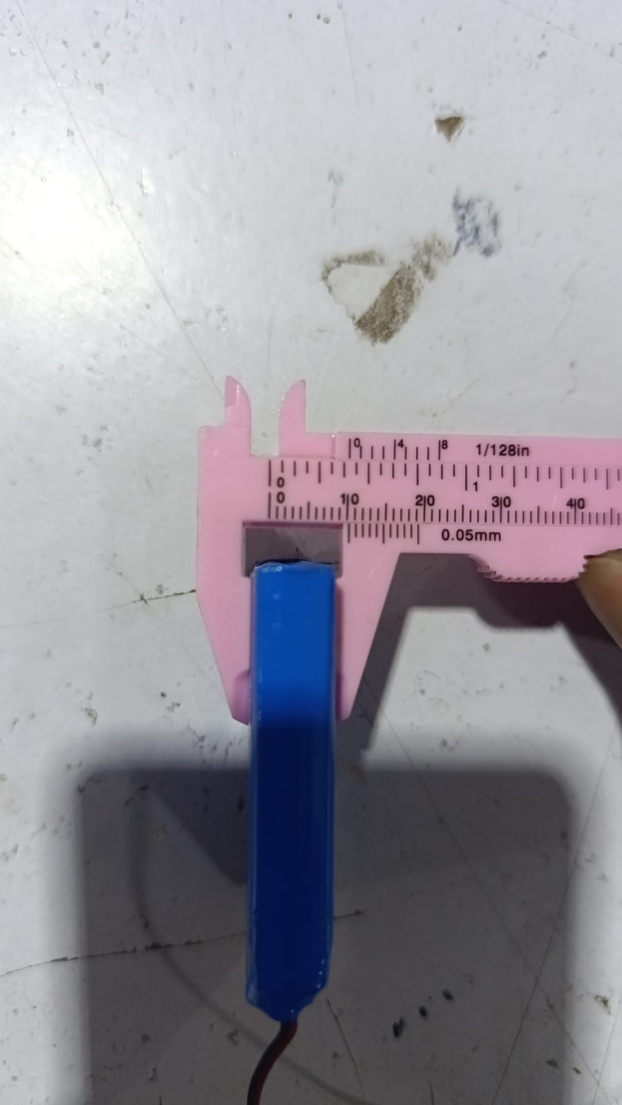 Battery Wholesale 2s 7.4V 1000mAh Rechargeable LiPo Lithium Battery Pack With JST 2.54mm Connector - a blue rectangular battery being measured by pink plastic calipers.