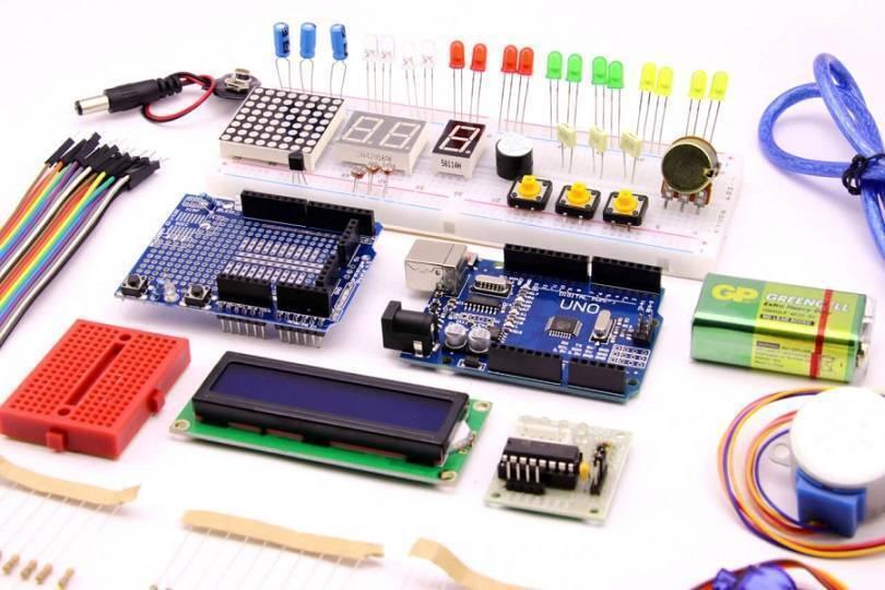 Beginner Arduino Uno Starter Kit - a blue microcontroller board, breadboards, LCD screen, LED lights, buttons, sensors, and connecting wires.
