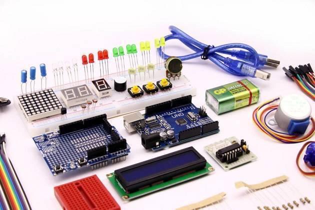 Beginner Arduino Uno Starter Kit - a blue Arduino Uno board, breadboard with LEDs, buttons, displays, LCD screen, motor, battery, and cables.