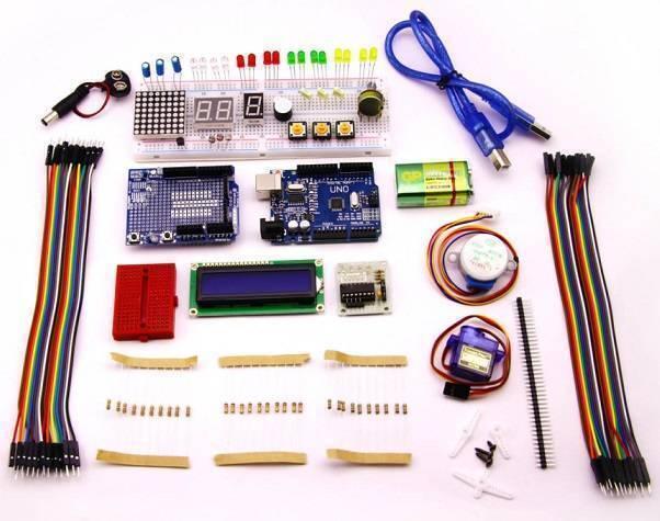 Beginner Arduino Uno Starter Kit - flat-lay of components including an Arduino Uno board, breadboard, LCD module, jumper wires, motor, and sensors.