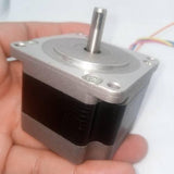 Bipolar NEMA23 1A Stepper Motor 4 Wire Stepper Motor - a silver and black square-bodied motor with a central metal shaft and multi-colored wires held in a hand.