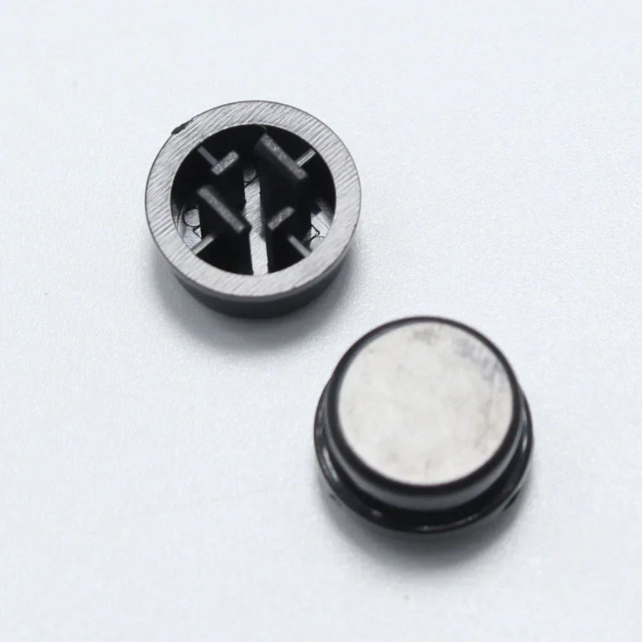 Black A24 Tactile Push Button Switch Cap for 12mm 12mm 7.3mm Micro Tact Switch - a close-up of two small, round, black plastic caps with internal cross-shaped mounting slots.