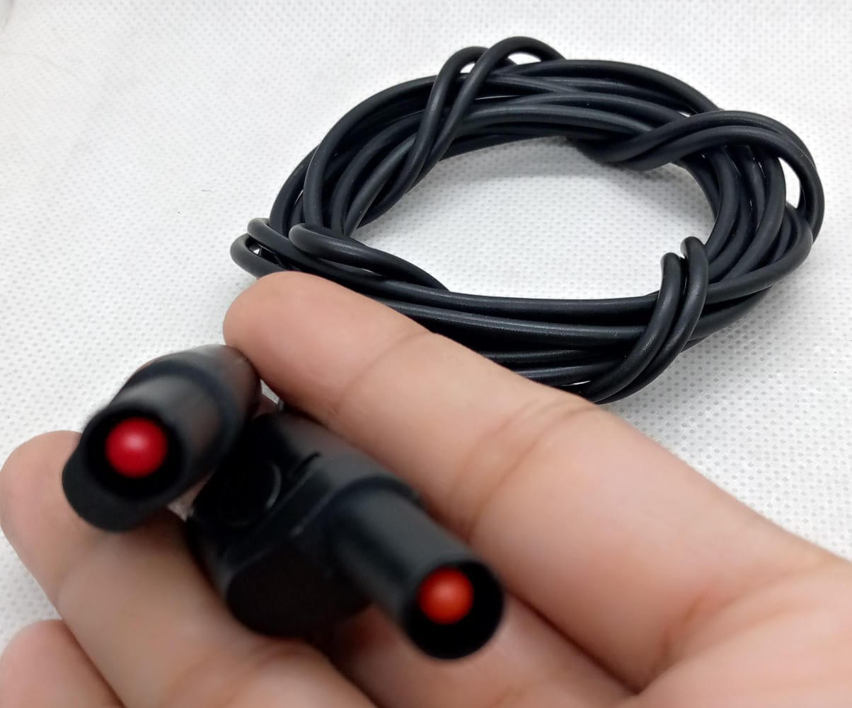 Black Banana Clip Wires 2 Meter | High-Quality Test Leads | Digilog.pk - a close-up of a hand holding two black connectors with red tips attached to a coiled black cable.