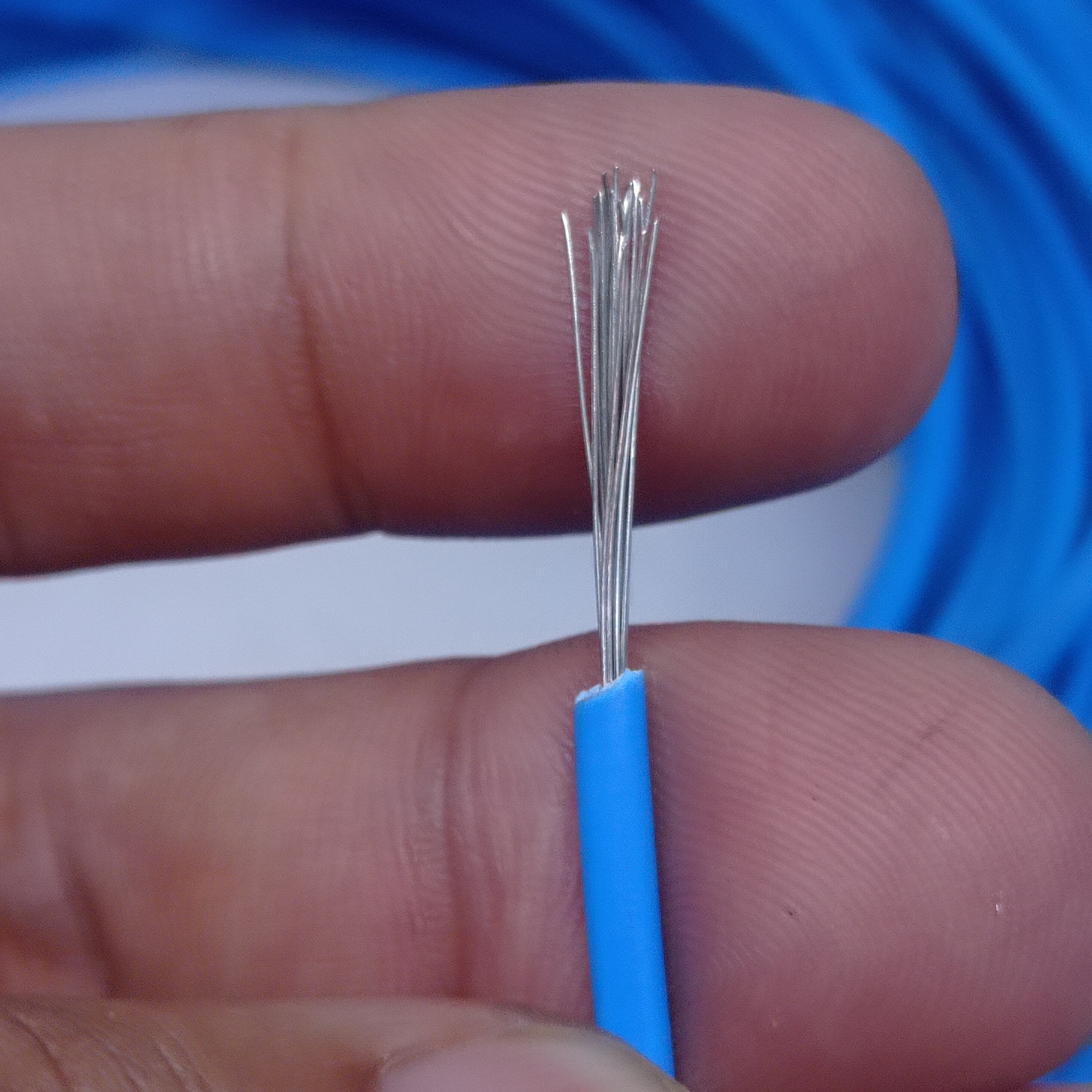 Blue 1.5mm Heat Resistance High Temperature Wire - shown in a close-up view held between fingers, displaying the stripped blue insulation and silver strands.
