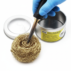 Brass Wire Sponge Soldering Iron Tip Cleaner with Metal Tin Box - a gloved hand using a soldering iron to clean the tip on a gold brass sponge.