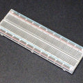 Breadboard MB102 830 Point Clear -transparent - a rectangular, clear plastic breadboard with 830 connection points and red and blue power rails.
