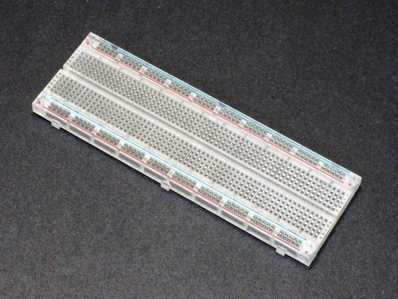Breadboard MB102 830 Point Clear -transparent - a rectangular, clear plastic breadboard with 830 connection points and red and blue power rails.