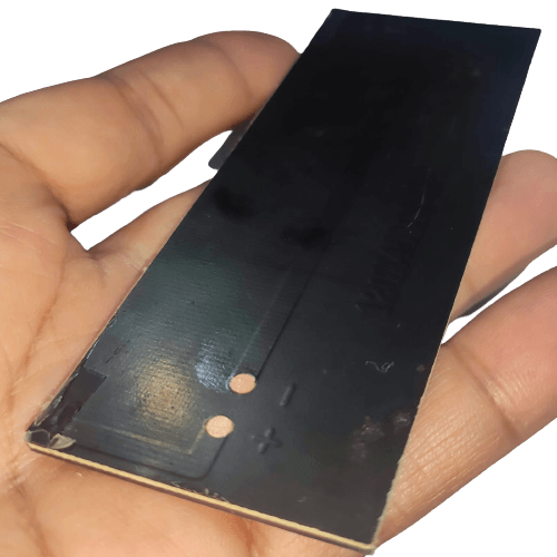 Buy 6V Mini Solar Cell Solar Module | Monocrystalline Solar Panel For DIY Projects At Digilog.pk - a rectangular black solar panel held in a hand, featuring visible positive and negative terminal markings.