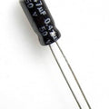 Capacitor 50V 0.47uF - a small black cylindrical electrolytic capacitor with two long metal wire leads extending from the bottom.