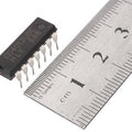 CD4013 d Type Flip Flop - shown as a black 14-pin integrated circuit chip positioned next to a metal ruler for scale.