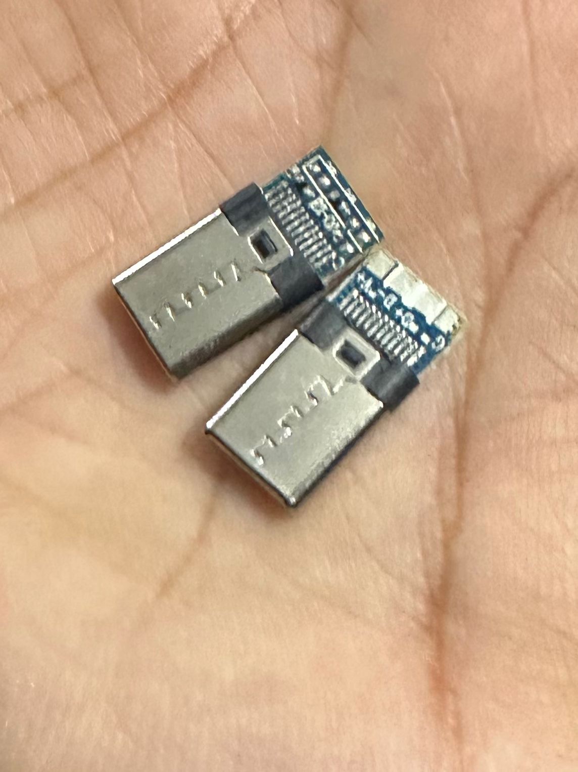 Connector USB 3.1 Type C Connector 16 Pin Male Socket - two silver and blue metal male connectors resting on a palm.