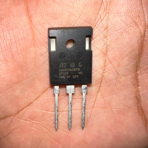 Copy 80N65 GW80H65 80H65 IGBT - a black three-pin electronic component held in a palm, featuring the STMicroelectronics logo and the text GWA80H65DFB printed on its face.