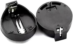 CR2032 Coin Cell Battery Holder - two black plastic circular battery holders with metal contact pins, one viewed from the top and one from beneath.