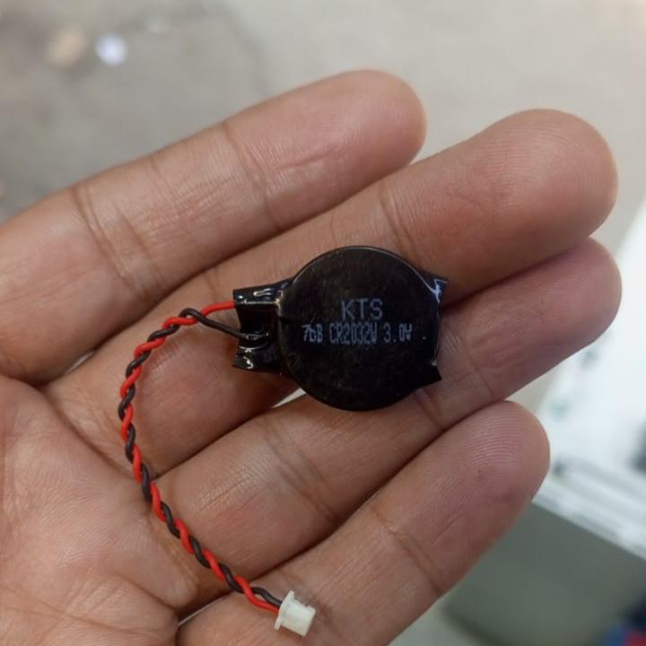 CR2032 With Wire - a black coin cell battery with red and black twisted wires ending in a small white two-pin connector, held in a hand.