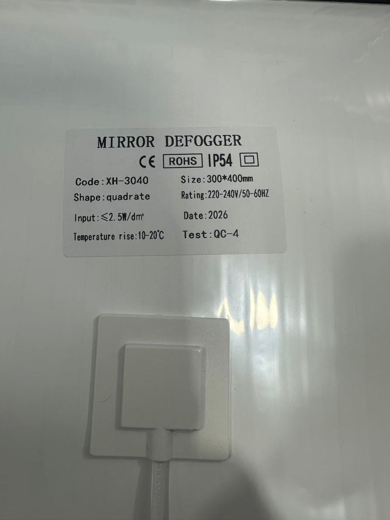 Customizable 300*400mm Bathroom Mirror Heating Pad Pet Electronic Defogger Film For Smart Mirror 220V Factory Direct - a white rectangular heating pad showing a product label with specifications including size, voltage, and IP54 rating, with a power cord.